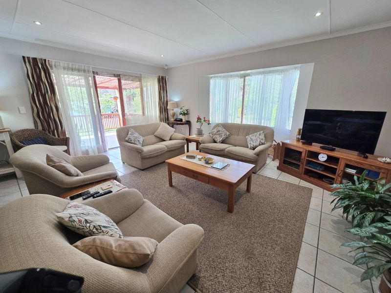 Spacious living room featuring tiled flooring, recessed lighting, and large windows with direct access to an outdoor patio area.