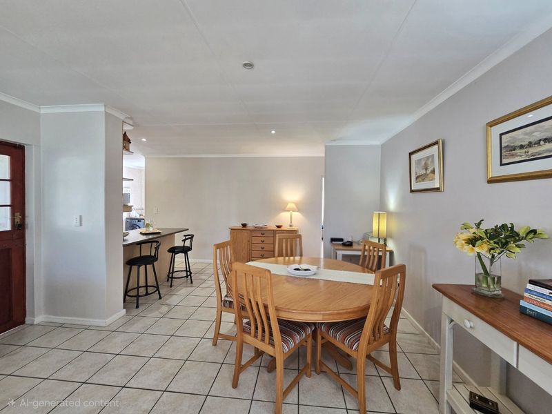 Open-plan dining and kitchen area featuring tiled flooring, recessed lighting, and a breakfast bar, creating a functional and connected living space.