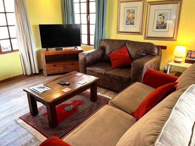 A cozy living room featuring laminate flooring and timber-framed windows, providing a warm and inviting atmosphere.