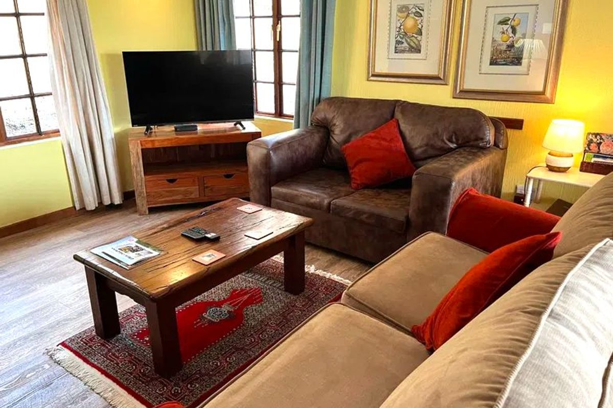 A cozy living room featuring laminate flooring and timber-framed windows, providing a warm and inviting atmosphere.