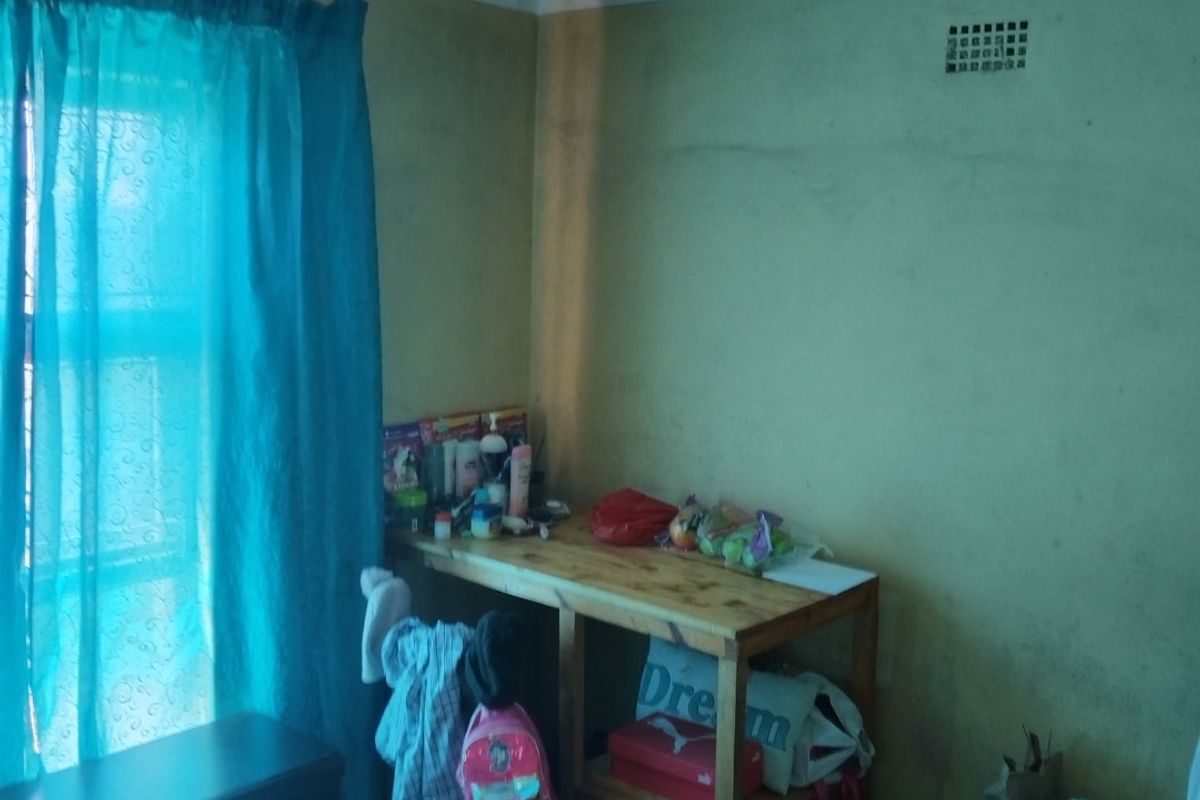 A bedroom space featuring a ventilation brick and plain wall finishes, requiring cosmetic updates and maintenance to improve the overall condition.