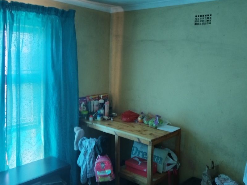 A bedroom space featuring a ventilation brick and plain wall finishes, requiring cosmetic updates and maintenance to improve the overall condition.