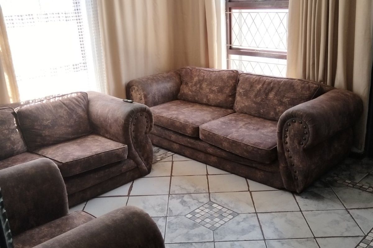 A living room featuring diamond-patterned floor tiles with decorative borders and diamond lattice window panes, providing a traditional aesthetic.