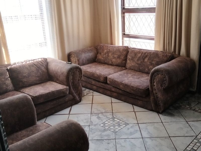 A living room featuring diamond-patterned floor tiles with decorative borders and diamond lattice window panes, providing a traditional aesthetic.