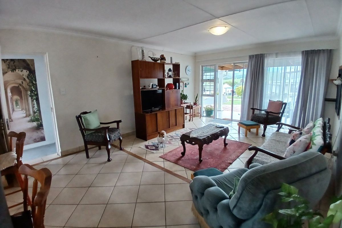 Spacious living room featuring neutral tiled flooring and large sliding glass doors that provide natural light and access to the outdoor patio area.