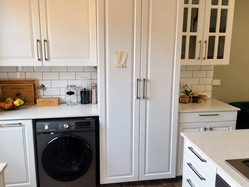 Modern kitchen featuring white shaker cabinetry, subway tile backsplash, quartz countertops, and an integrated washing machine with a built-in gas cooktop.
