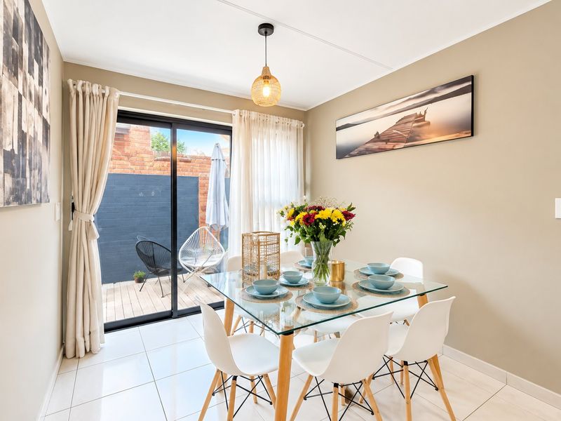 Bright dining area featuring tiled flooring and a large sliding glass door providing direct access to the outdoor patio space.