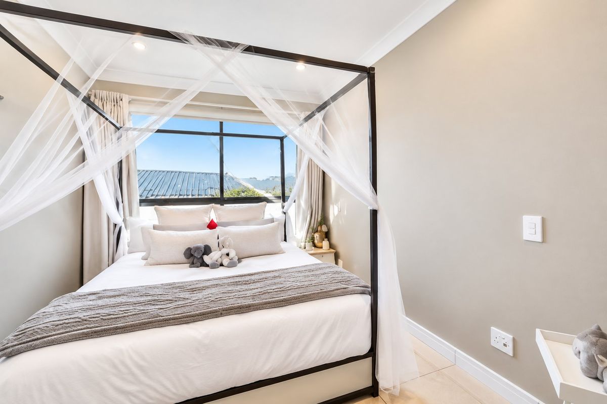 A bright and well-maintained bedroom featuring tiled flooring, recessed downlighting, and large windows with views.