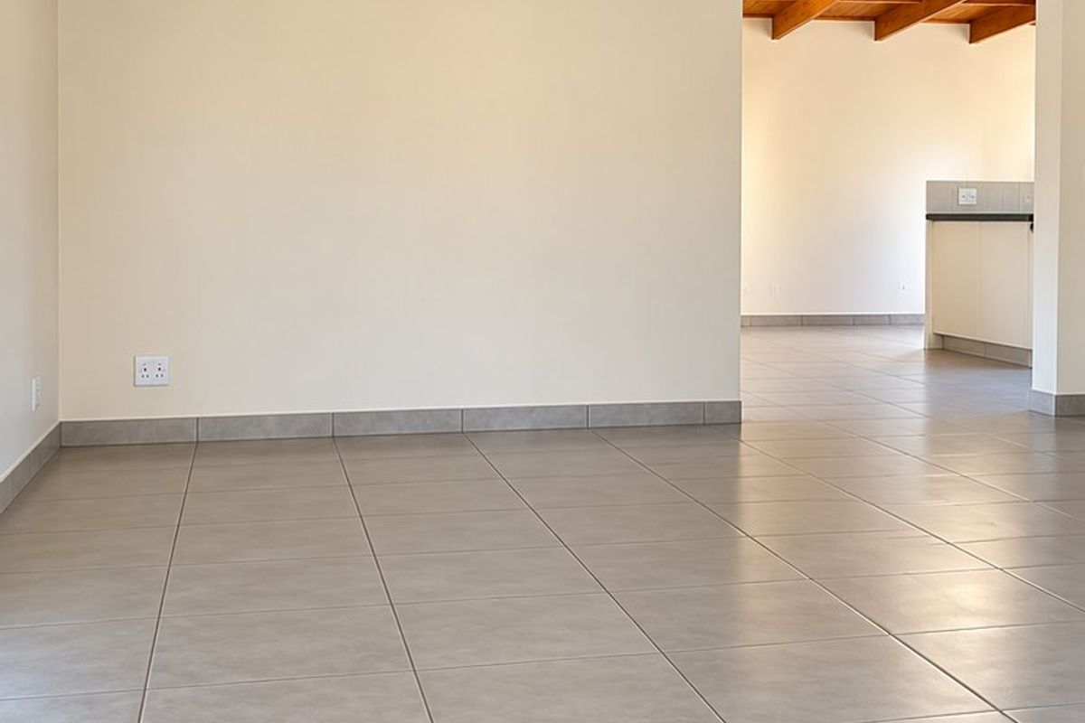 Spacious living area featuring high exposed timber beam ceilings and neutral tiled flooring, offering a bright and open layout.