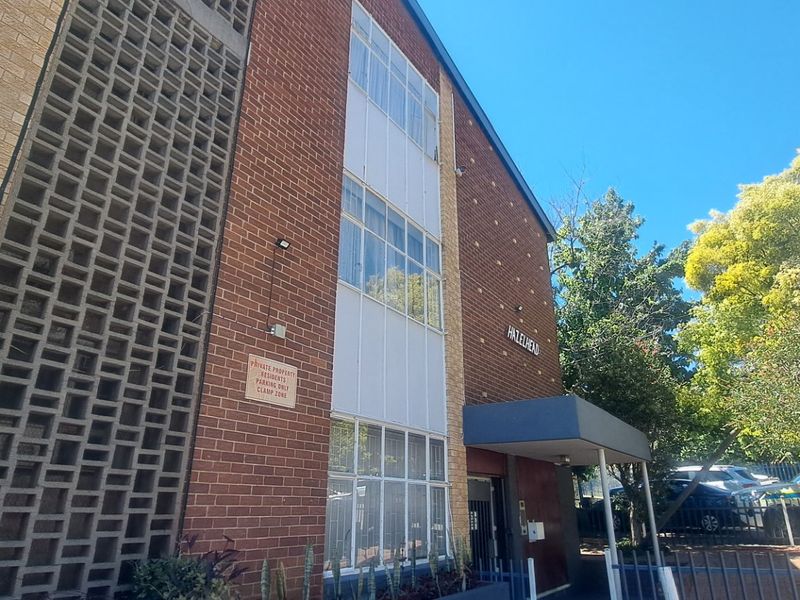Exterior view of the Hazelhead apartment building featuring a brick facade, decorative breeze block screen, and a covered entrance canopy.