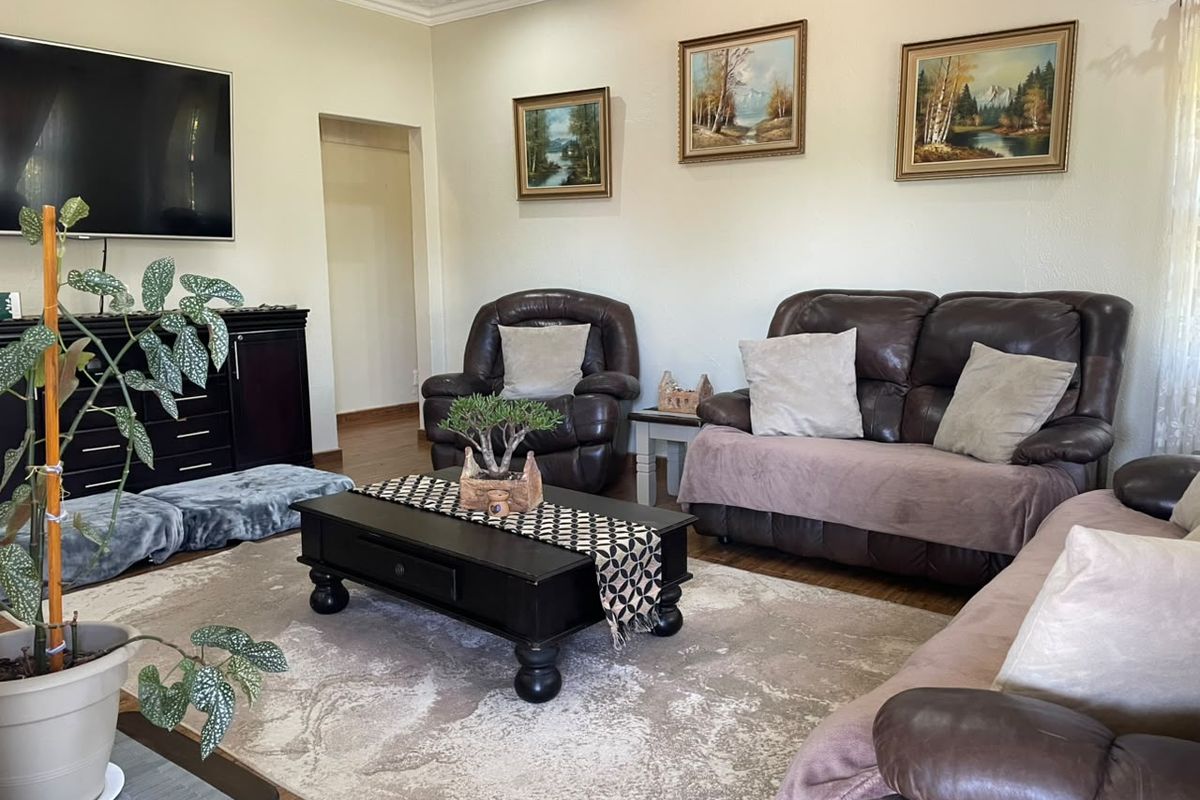 A comfortable living room featuring textured ceilings and laminate flooring, providing a neutral base for personalization.