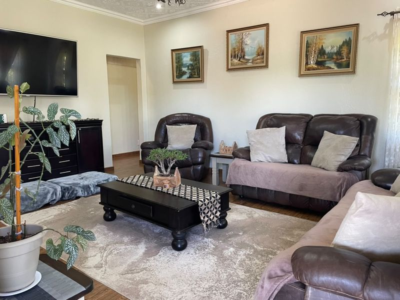 A comfortable living room featuring textured ceilings and laminate flooring, providing a neutral base for personalization.