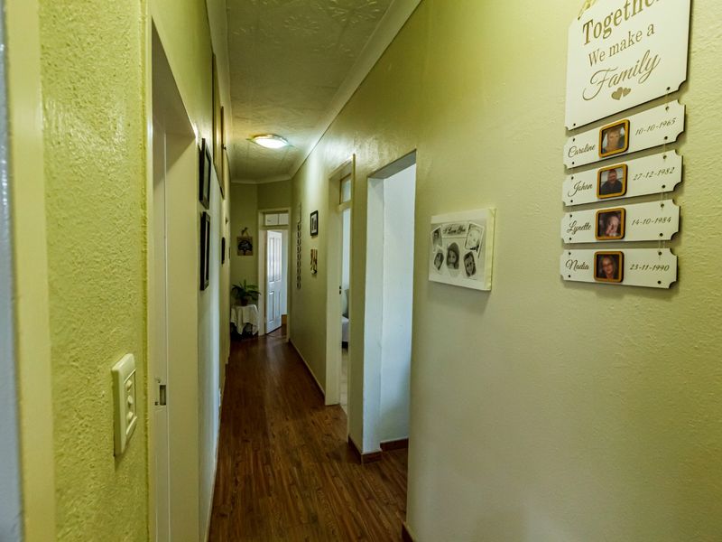 A functional hallway featuring laminate flooring and neutral wall finishes, providing access to multiple rooms within the home.