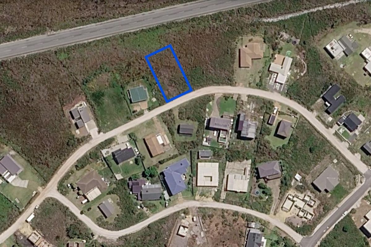 Aerial view of a vacant residential land plot situated in a developed neighborhood with established road access.