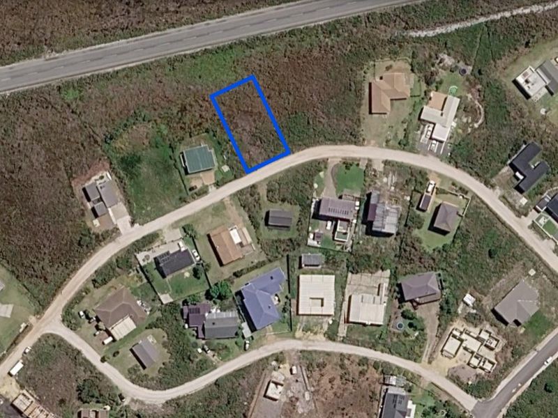 Aerial view of a vacant residential land plot situated in a developed neighborhood with established road access.