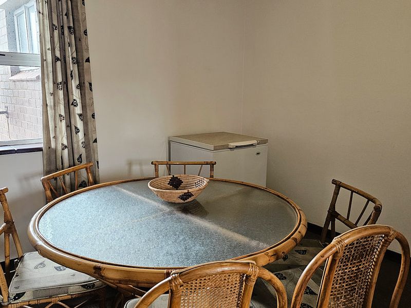 A simple dining area featuring a window with curtains, providing a functional space for meals.