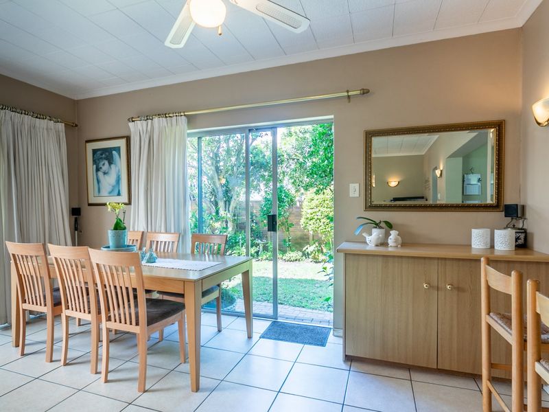 Dining room featuring tiled flooring, built-in cabinetry, and sliding glass doors providing direct access to the garden area.