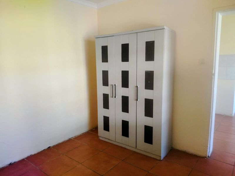 A bedroom featuring tiled flooring and neutral wall finishes, providing a blank canvas for potential interior updates.
