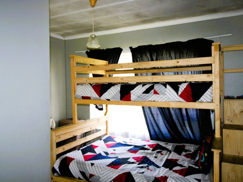 A bedroom featuring a bunk bed setup with visible ceiling staining and signs of wear on the wall finishes.