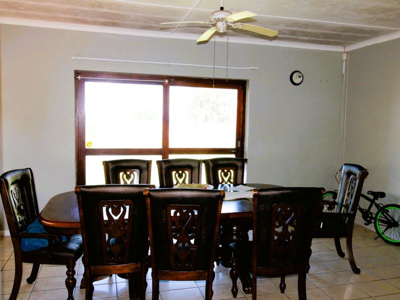 Dining room featuring tiled flooring, a ceiling fan, and a large sliding glass door providing natural light.