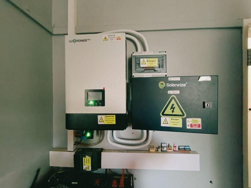 A wall-mounted solar power inverter and electrical distribution board system, showing modern renewable energy infrastructure.