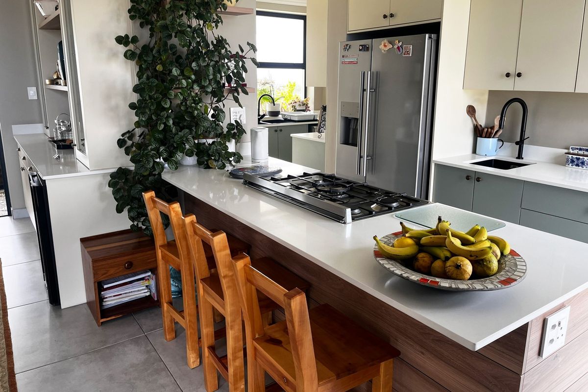 Modern kitchen featuring a central island with a gas cooktop, quartz countertops, ample cabinetry, and a sleek undermount sink with a gooseneck faucet.