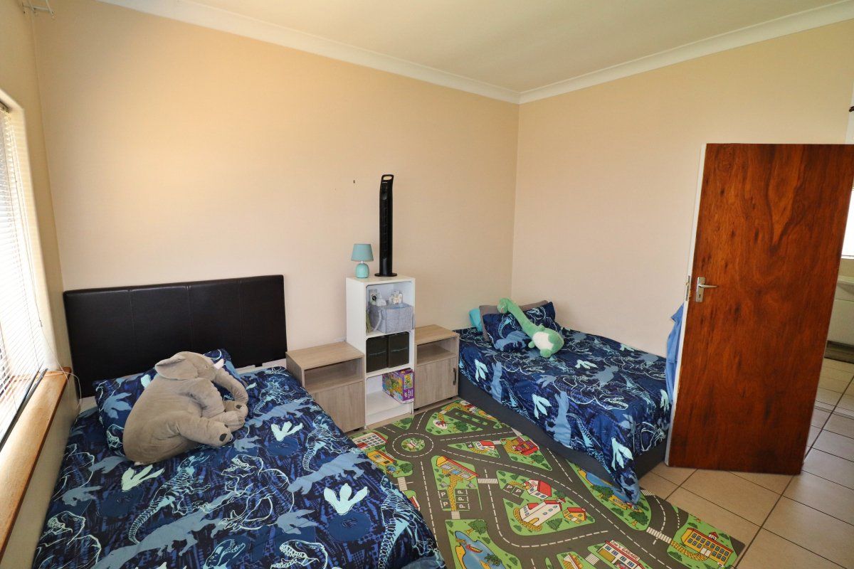 A functional bedroom featuring tiled flooring, neutral wall finishes, and coving, providing a versatile space for a child's room or guest accommodation.