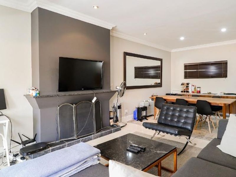 Spacious open-plan living and dining area featuring a central fireplace, recessed lighting, and neutral wall finishes, providing a versatile layout for modern living.