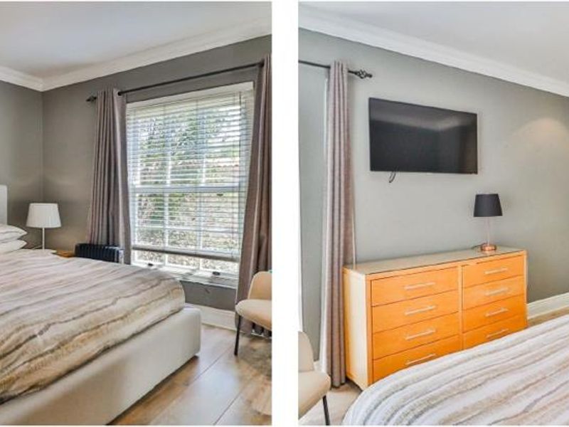 A well-maintained bedroom featuring laminate flooring, recessed downlighting, crown molding, and built-in cupboards.