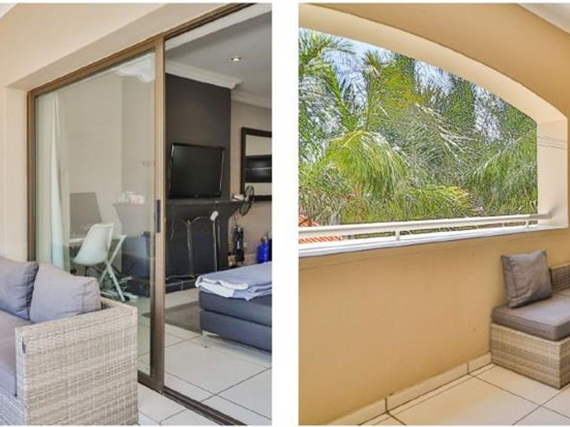 A covered balcony featuring tiled flooring, a metal balustrade, and a sliding glass door providing access to the interior living space.