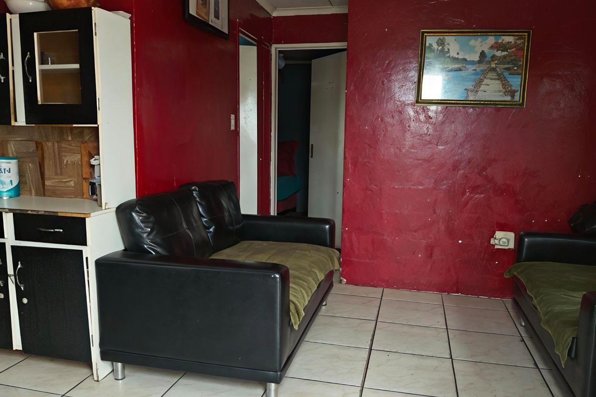 Living room area featuring tiled flooring and built-in cabinetry, with red textured walls and access to adjacent rooms.