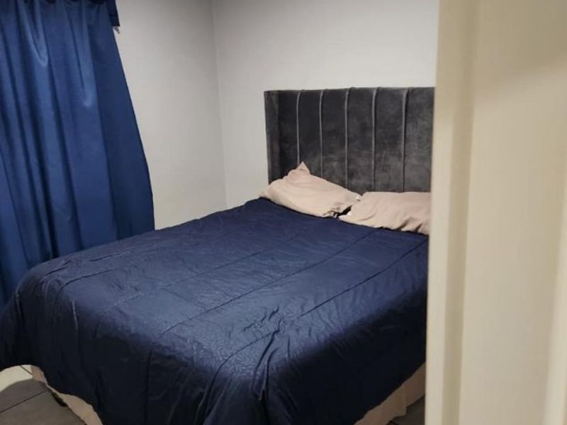 A bedroom featuring tiled flooring and neutral wall finishes, viewed from the doorway.