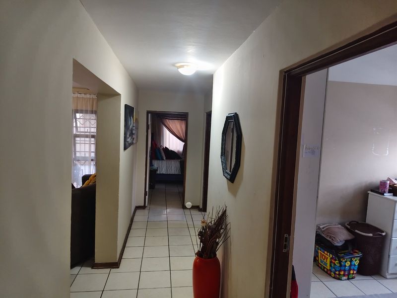 A central hallway featuring tiled flooring and access to multiple rooms, providing a functional transition space within the apartment.