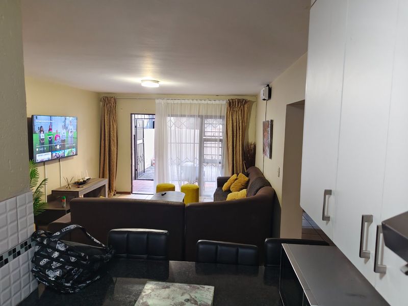 Open plan living area featuring a kitchen with granite countertops and a seamless transition to the lounge area with access to an outdoor space.