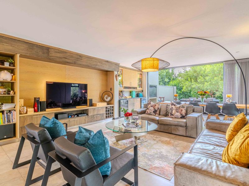 Spacious open-plan living area featuring custom built-in cabinetry, integrated shelving, and large sliding glass doors that provide seamless access to the outdoor space.