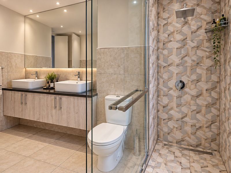 Modern bathroom featuring a double vanity with vessel sinks, a spacious walk-in shower with geometric tiling, and high-quality finishes throughout.