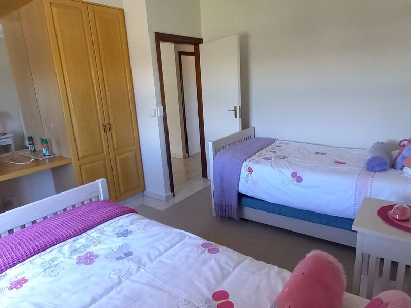A bedroom featuring built-in wooden wardrobes and a matching integrated vanity unit, providing ample storage space.