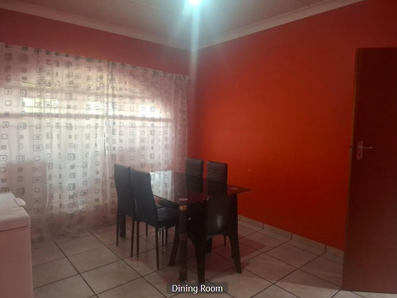 A dining room featuring tiled flooring and coved ceilings, currently painted in a bold red tone.