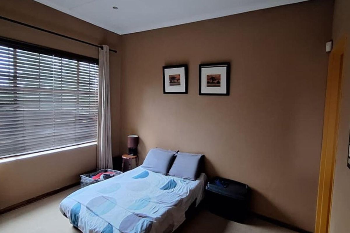 A standard bedroom featuring neutral wall paint, venetian blinds, and fitted curtain rails, offering a functional and comfortable living space.
