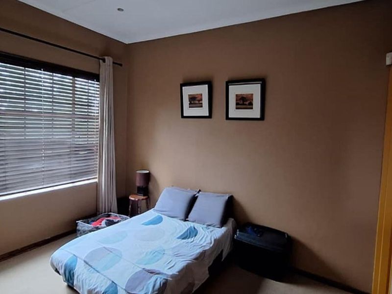 A standard bedroom featuring neutral wall paint, venetian blinds, and fitted curtain rails, offering a functional and comfortable living space.