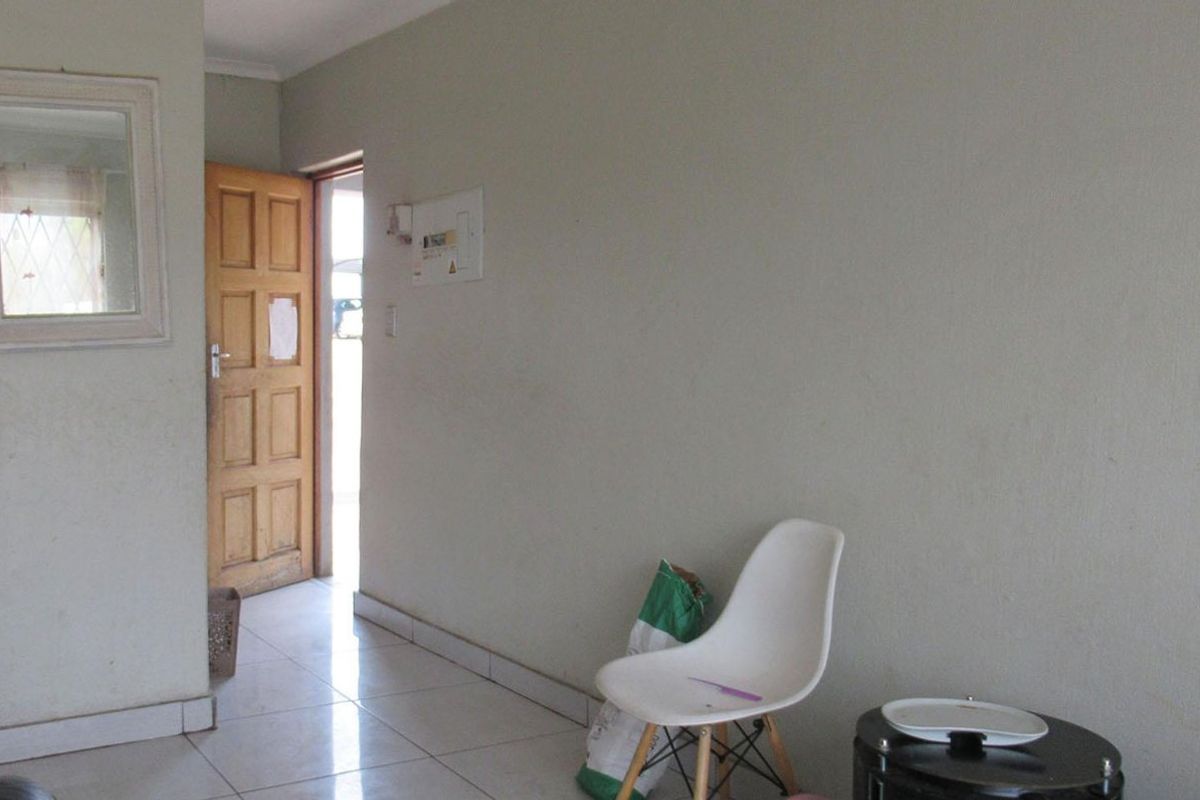 An entry area featuring tiled flooring and a timber panel door, providing access to the apartment interior.