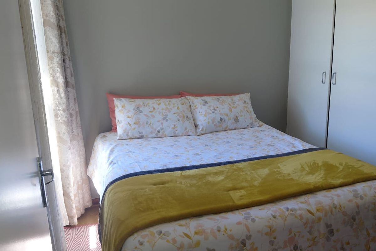 A functional bedroom featuring a built-in wardrobe and neutral wall finishes, providing a comfortable and practical sleeping space.