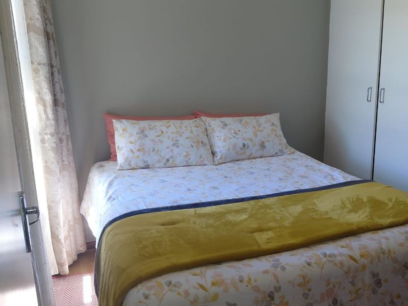 A functional bedroom featuring a built-in wardrobe and neutral wall finishes, providing a comfortable and practical sleeping space.