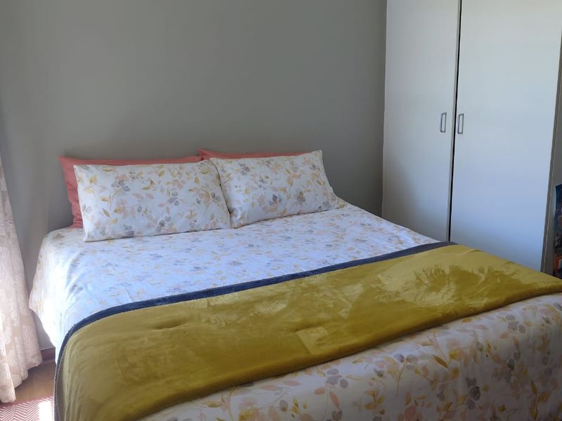 A functional bedroom featuring a built-in wardrobe and neutral wall finishes, providing a comfortable and practical sleeping space.
