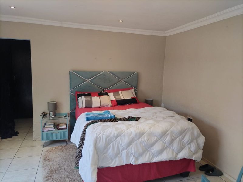 A standard bedroom featuring tiled flooring, recessed downlighting, and coved ceiling details.
