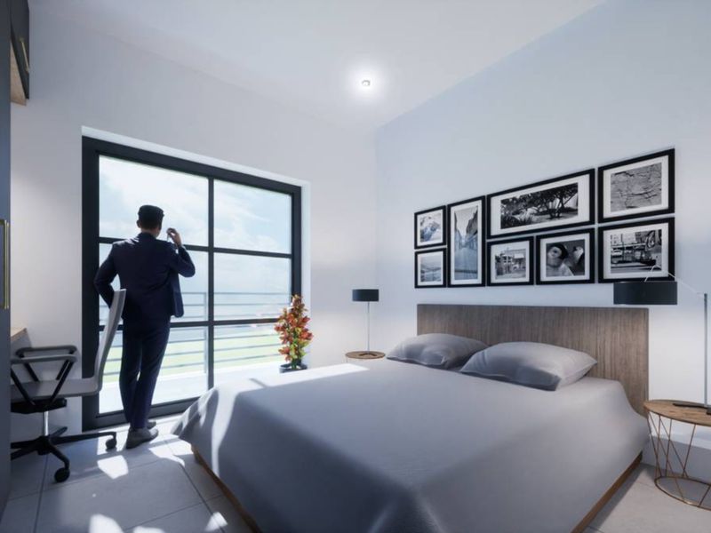 Modern bedroom featuring a built-in wardrobe, tiled flooring, and a large glass sliding door providing natural light and access to the exterior.