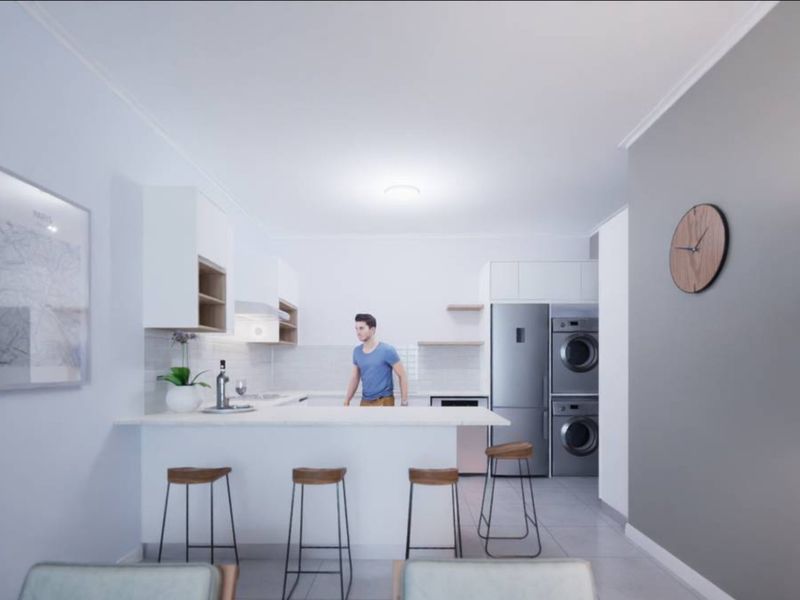 Modern open-plan kitchen featuring white cabinetry, stone countertops, tiled backsplash, and integrated laundry appliances in a clean, contemporary design.