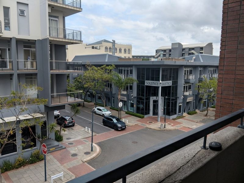 An elevated view overlooking a modern urban streetscape with contemporary apartment buildings and commercial office spaces.