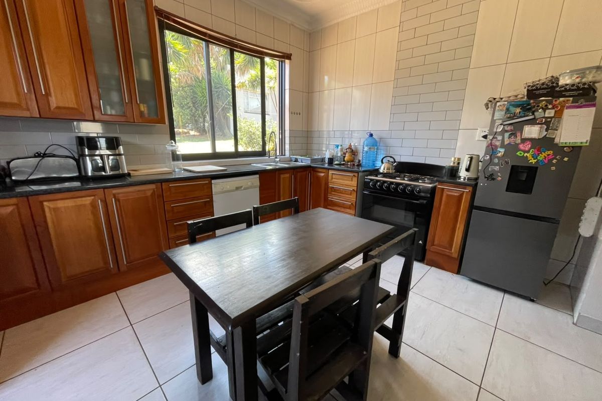 A functional kitchen featuring wooden cabinetry, granite countertops, subway tile backsplash, and tiled flooring, offering a practical layout for daily cooking and dining.