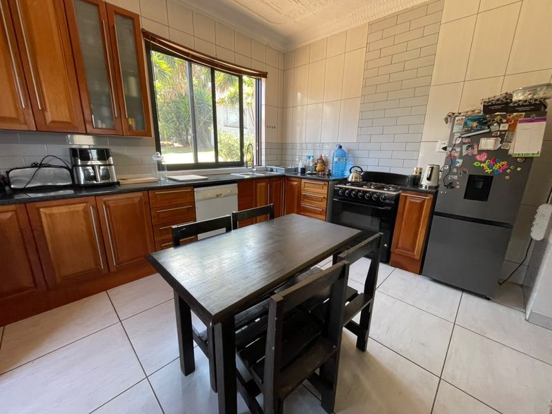 A functional kitchen featuring wooden cabinetry, granite countertops, subway tile backsplash, and tiled flooring, offering a practical layout for daily cooking and dining.